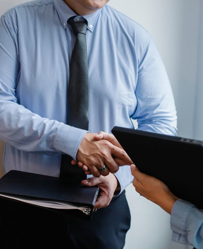 Inicio Business handshake between colleagues in a formal office meeting setting.