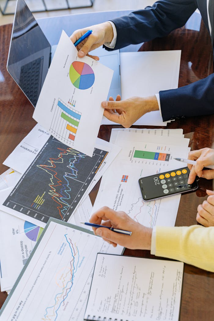 Sobre Nosotros Business professionals analyzing financial charts and graphs during a meeting.