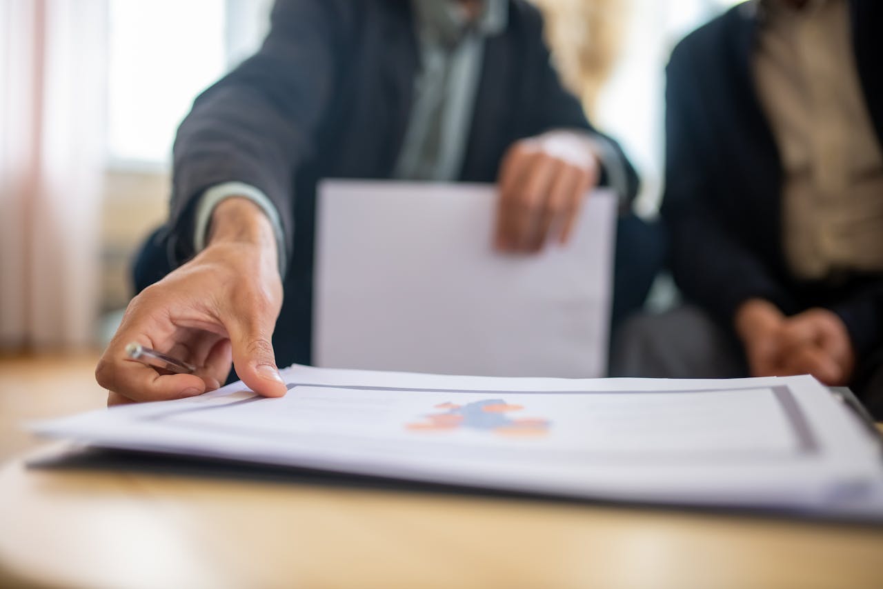 Inicio Close-up of a businessman reviewing important documents at a desk in an office setting.